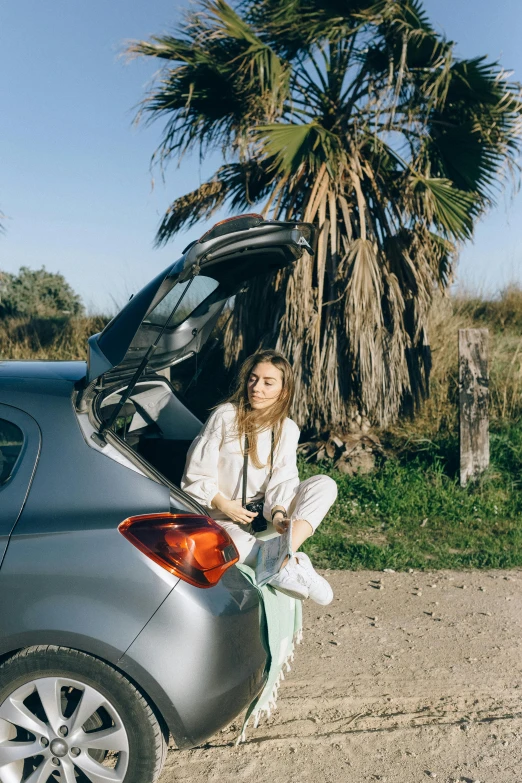 a woman sitting in the trunk of a car, by Nathalie Rattner, pexels contest winner, lookbook, al fresco, promotional image, in spain