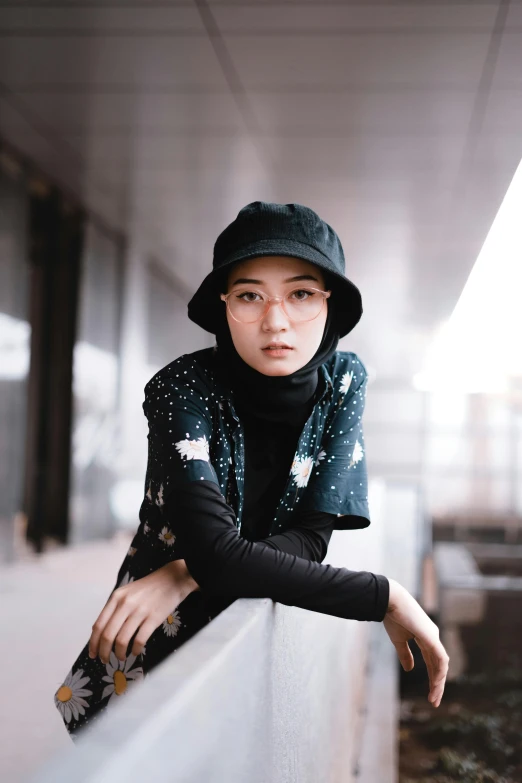 a woman sitting on a ledge with a skateboard, inspired by Cheng Jiasui, trending on unsplash, realism, hijab, with rap cap on head, looking straight to camera, patterned clothing