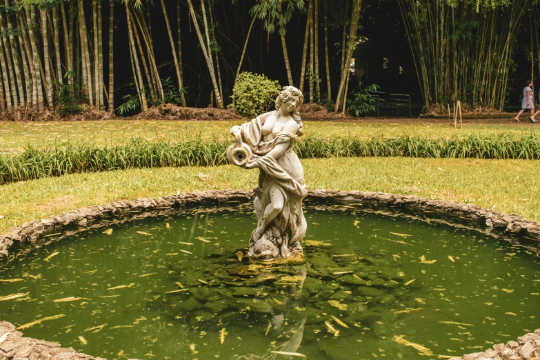 a statue sitting in the middle of a pond, a statue, pexels contest winner, lush garden surroundings, tamborine, regency-era, preserved historical