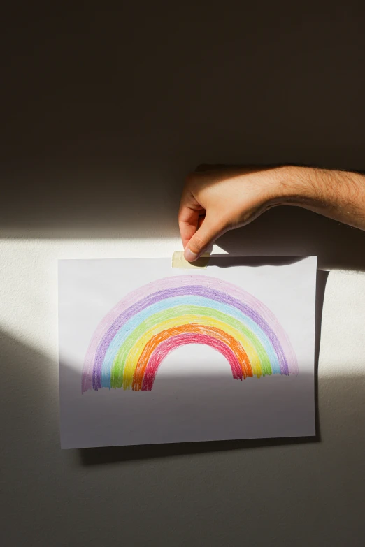 a person holding a piece of paper with a rainbow drawn on it, sunbeam, asher duran, 2019 trending photo, ethan klein