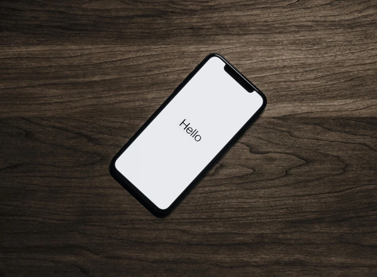 a cell phone sitting on top of a wooden table, by Niko Henrichon, trending on pexels, hello world, minimalist svg, hq 4k phone wallpaper, rounded corners