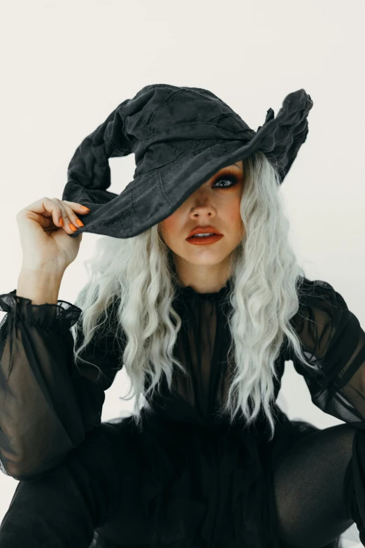 a woman with white hair wearing a black witch hat, trending on pexels, messy wavy white hair, hot topic, ashy, square