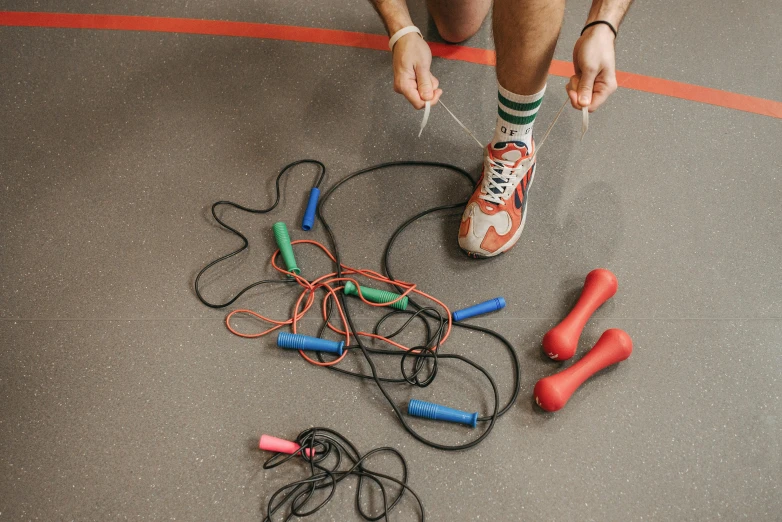 a person standing next to a bunch of wires, working out, knobbly knees, sports setting, top-down shot