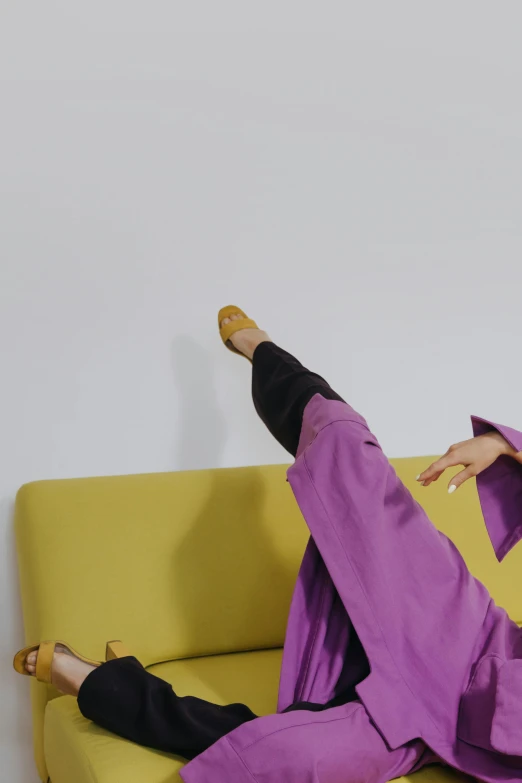 a woman sitting on top of a yellow couch, inspired by Fei Danxu, wearing black and purple robes, breakdancing, showstudio, wearing an academic gown
