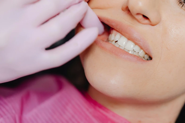 a woman getting her teeth brushed by a dentist, by Lee Loughridge, trending on pexels, aestheticism, square jaw-line, flat colour, pink lips, side view close up of a gaunt