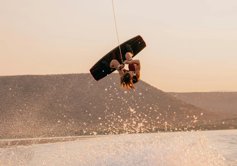 a man flying through the air while riding a wake board, pexels contest winner, figuration libre, pink golden hour, hanging upside down, lachlan bailey, slightly tanned