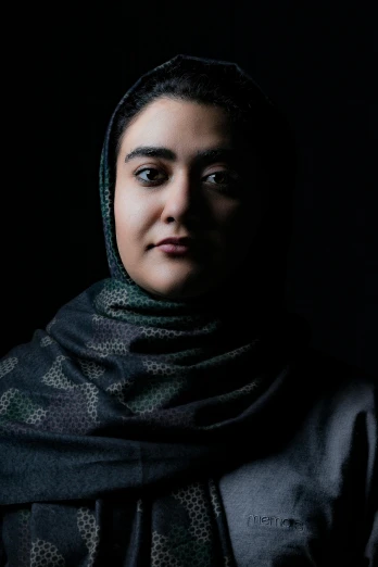 a close up of a person wearing a scarf, by Maryam Hashemi, standing with a black background, zaha hadi, ((portrait)), promotional image