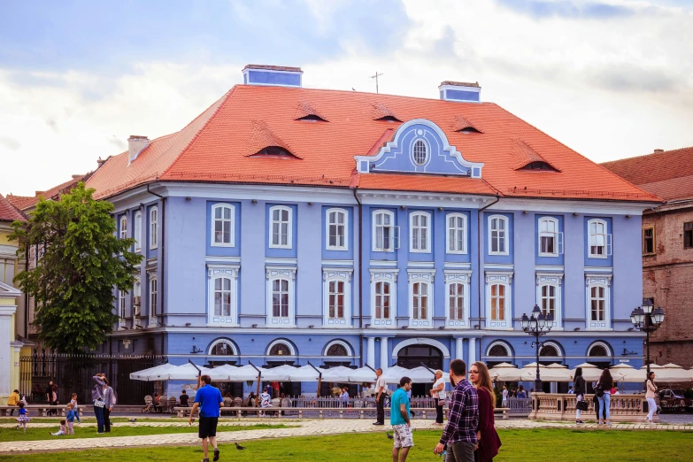 a group of people standing in front of a blue building, capital of estonia, fan favorite, audrey plaza, profile image