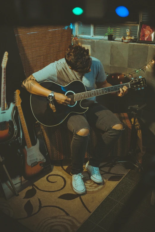 a man sitting in a chair playing a guitar, an album cover, inspired by John Luke, pexels contest winner, happening, profile pic, low quality grainy, sunfaded, damian kryzwonos