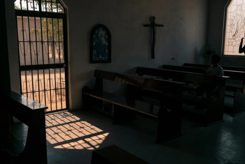 a person sitting on a bench in a church, pexels, light and space, mexico, contre - jour, inside elementary school, seen from outside