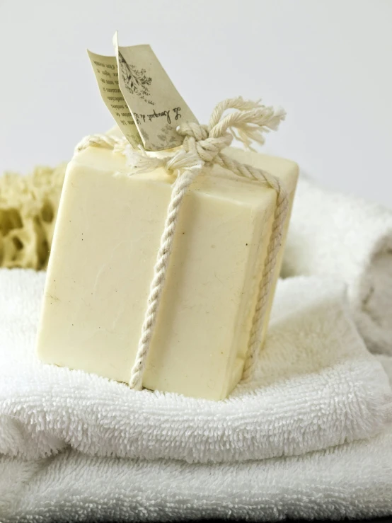 a bar of soap sitting on top of a pile of towels, a picture, square, olive oil, organic ceramic white, thumbnail