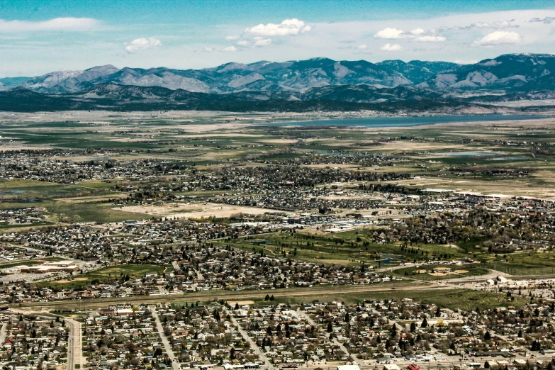 an aerial view of a city with mountains in the background, a colorized photo, by Dan Scott, wyoming, canvas, high quality upload, multiple stories