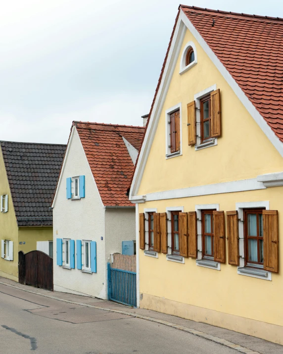 a couple of houses sitting on the side of a road, by Werner Gutzeit, pexels contest winner, renaissance, pale yellow walls, exterior view, square, set in ww2 germany