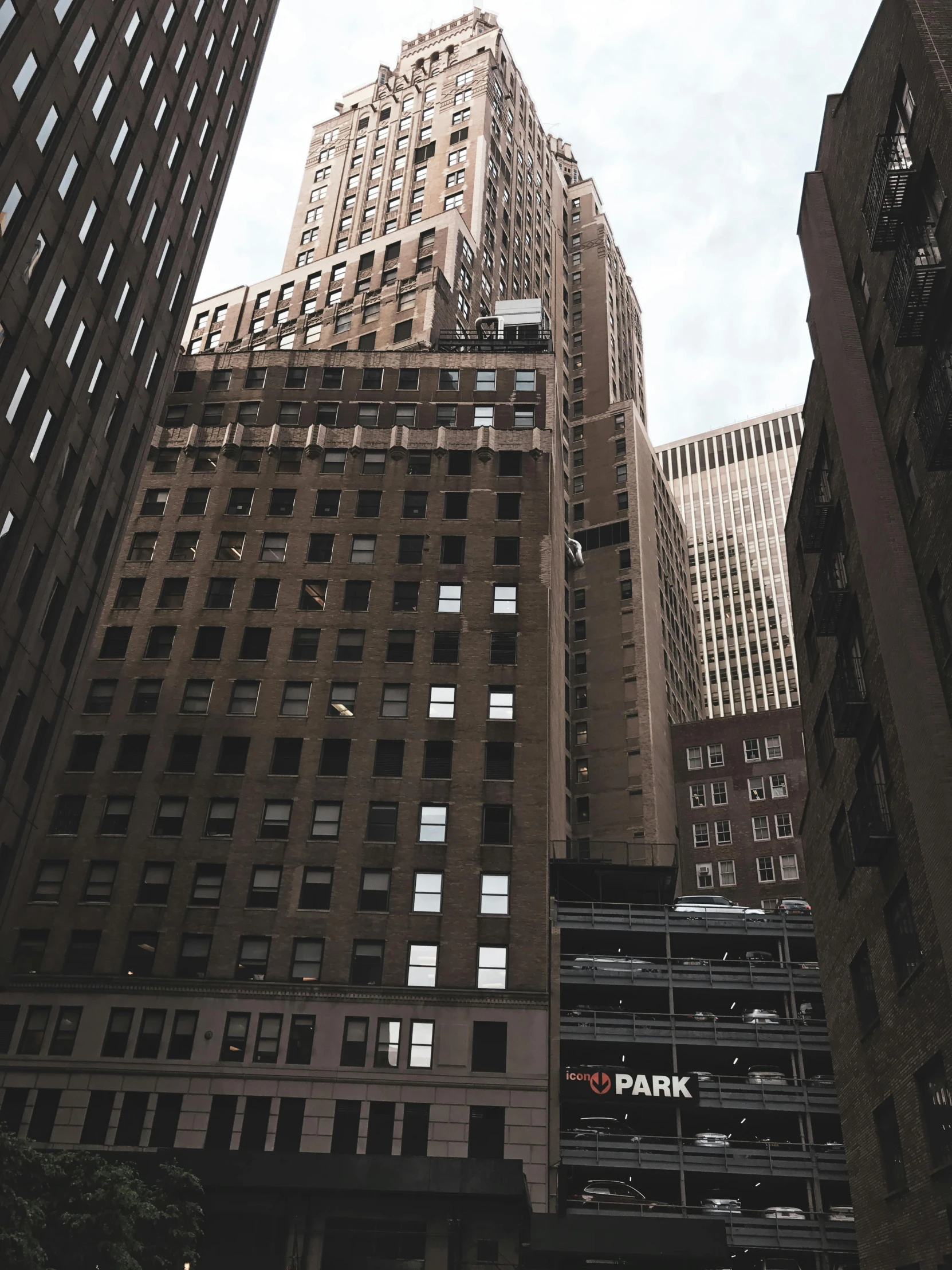 a very tall building sitting in the middle of a city, by Adam Rex, pexels contest winner, modernism, wall street, gray skies, new york buildings, dark. no text