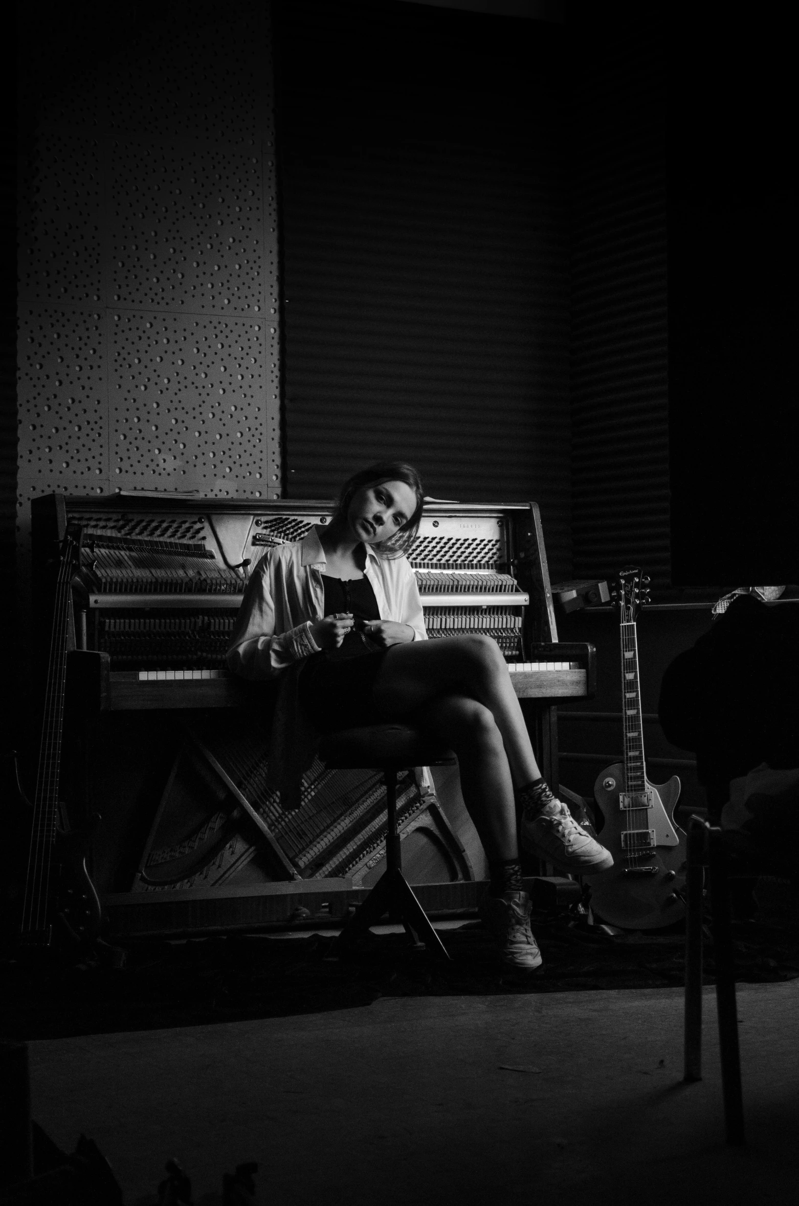 a man sitting on a chair in front of a piano, a black and white photo, by andrei riabovitchev, the girl plays the guitar, ashteroth, studio recording, female