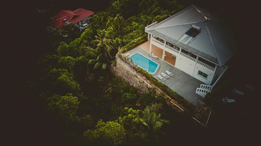 an aerial view of a house with a swimming pool, pexels contest winner, mountainous jungle setting, views to the ocean, built on a steep hill, high quality image”