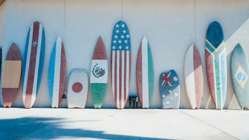 a row of surfboards lined up against a wall, by Carey Morris, pexels contest winner, concrete art, american flags, terrazzo, g 7 summit, painted marble sculptures