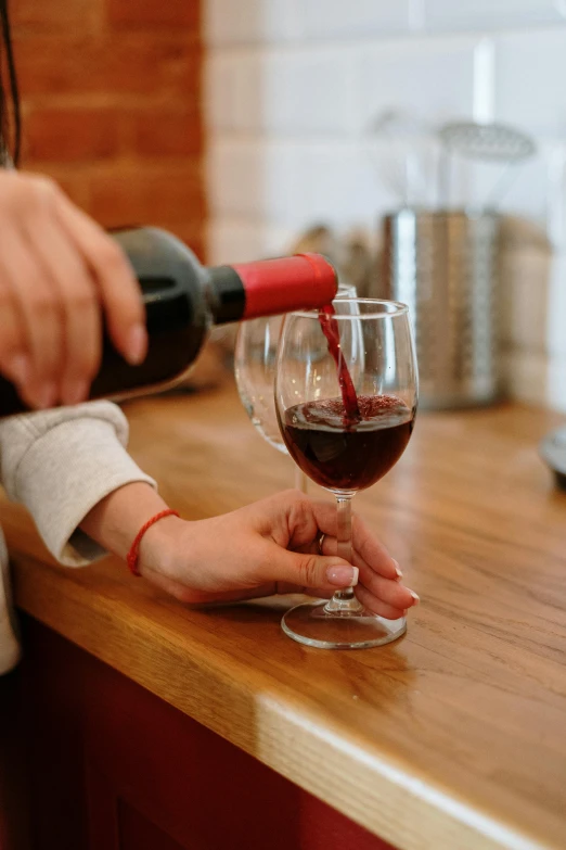 a woman pouring a glass of wine into a wine glass, pexels contest winner, maroon, fully functional, bottle, enhanced