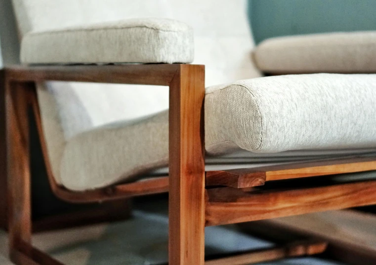 a white couch sitting on top of a wooden floor, inspired by Constantin Hansen, unsplash, visual art, wood chair, close up details, wooden trim, up-close