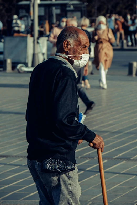 an old man wearing a face mask and walking with a cane, a picture, pexels contest winner, urban setting, colored photo, sickness, black man