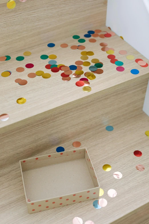 a close up of a set of stairs with confetti, wood effect, for kids, sleek round shapes, foil