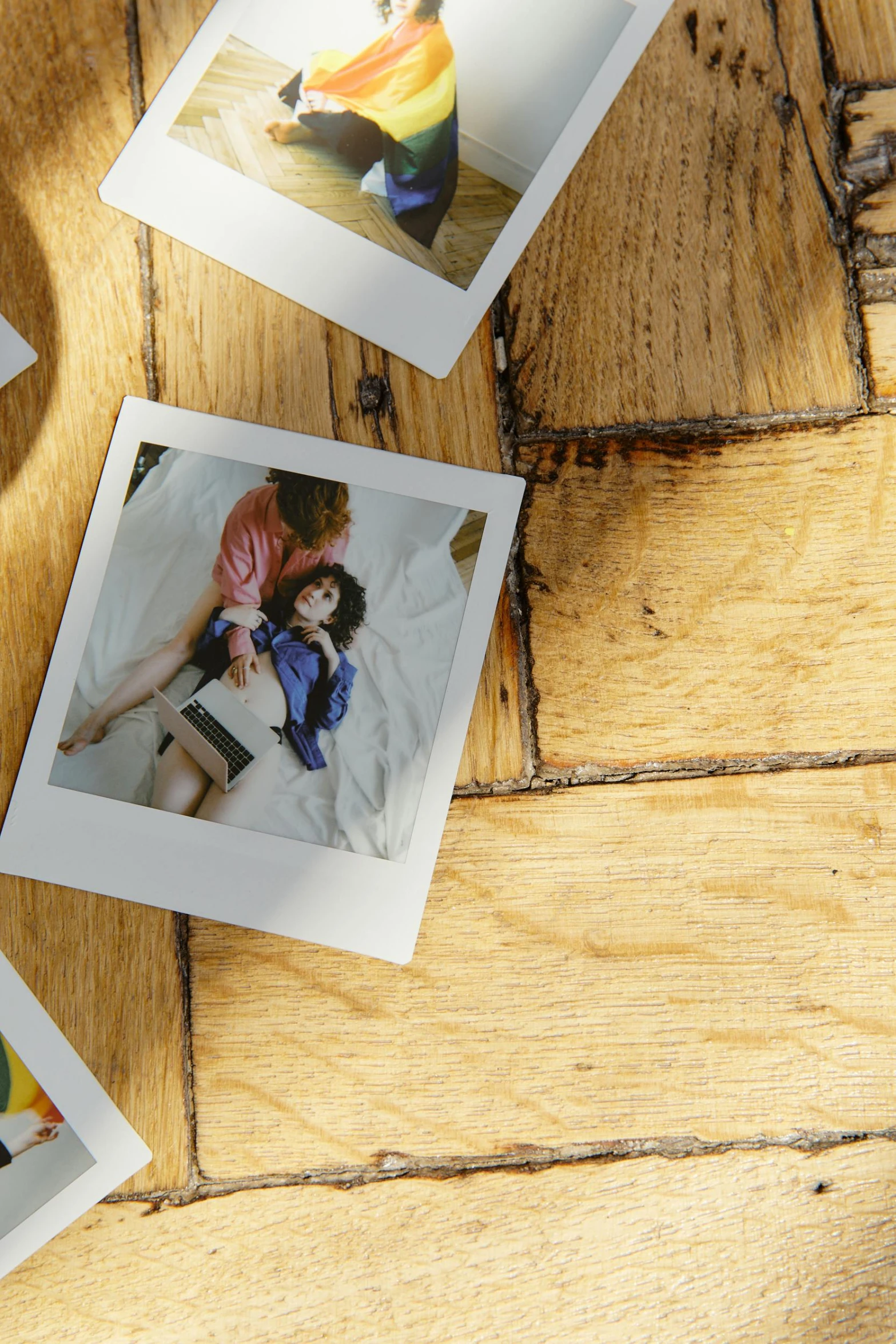 a couple of polaroids sitting on top of a wooden floor, flatlay, photo of a model, vinyl material, digital image