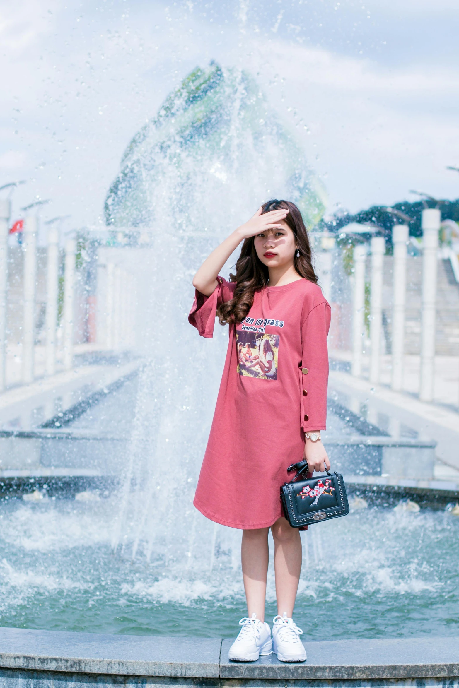 a woman standing in front of a fountain, by Cherryl Fountain, happening, casual streetwear, pink and red color style, in style of lam manh, official product image
