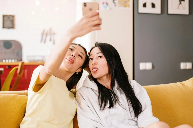 two women sitting on a couch taking a selfie, trending on pexels, asian face, 🦩🪐🐞👩🏻🦳, avatar image, high school