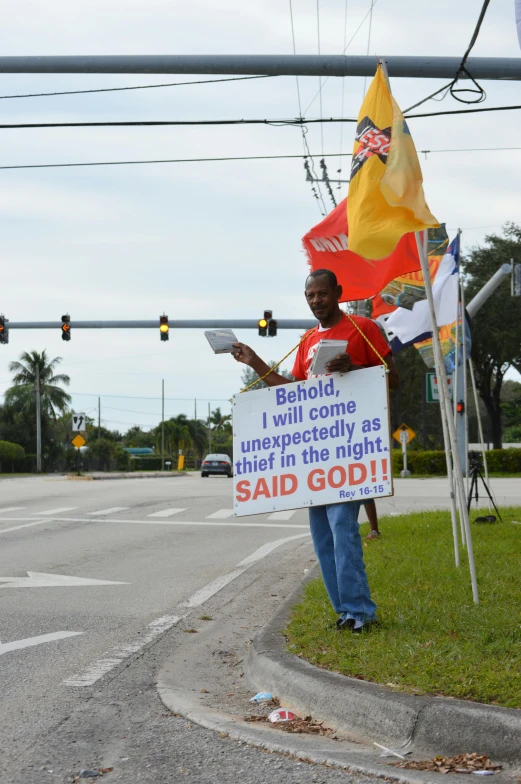 a man holding a sign on the side of a road, flickr, florida man, deity), holding a red banner, god rays!!!