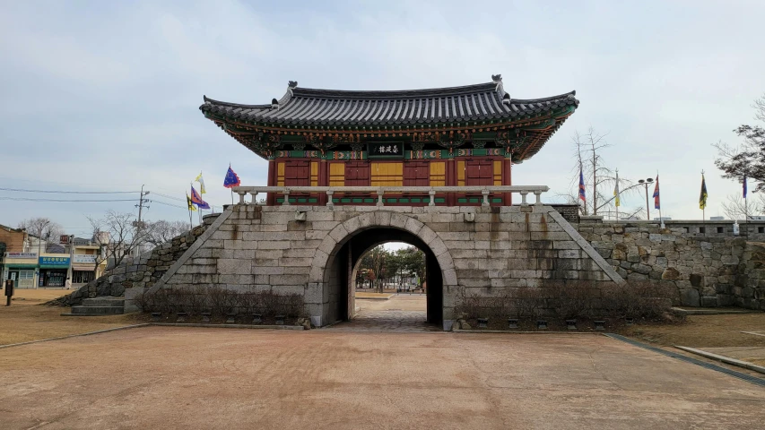 a stone building with a gate in front of it, by Jang Seung-eop, pexels contest winner, cloisonnism, square, giant archways, military buildings, sangsoo jeong