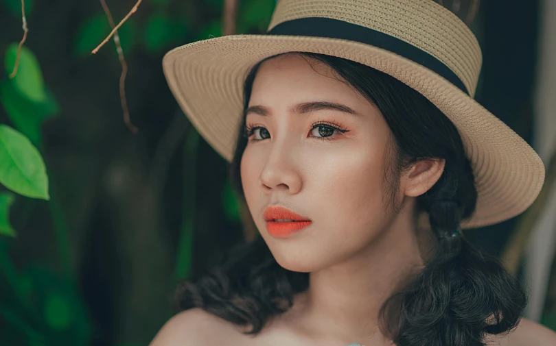 a close up of a woman wearing a hat, inspired by Itō Shinsui, trending on pexels, coral lipstick, young asian girl, straw, vietnamese woman