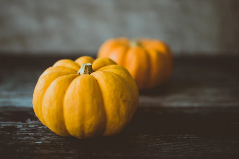 three small pumpkins sitting on top of a wooden table, unsplash, 2 5 6 x 2 5 6 pixels, a pair of ribbed, mid body shot, petite