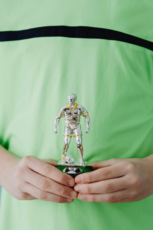 a person holding a toy robot in their hands, a statue, inspired by Thomas Scholes, dribble contest winner, holography, silver with gold trim, model kit, medium - shot, metal body