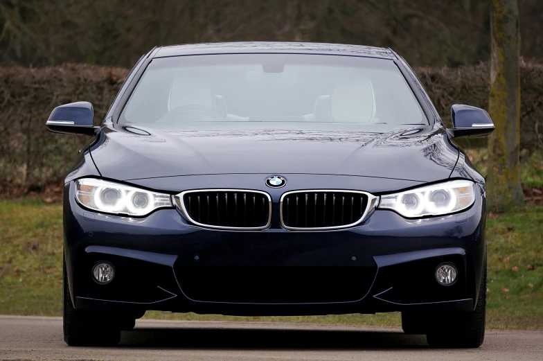a blue bmw car driving down a road, pexels contest winner, renaissance, front of car angle, immaculate shading, transparent black windshield, frontlight