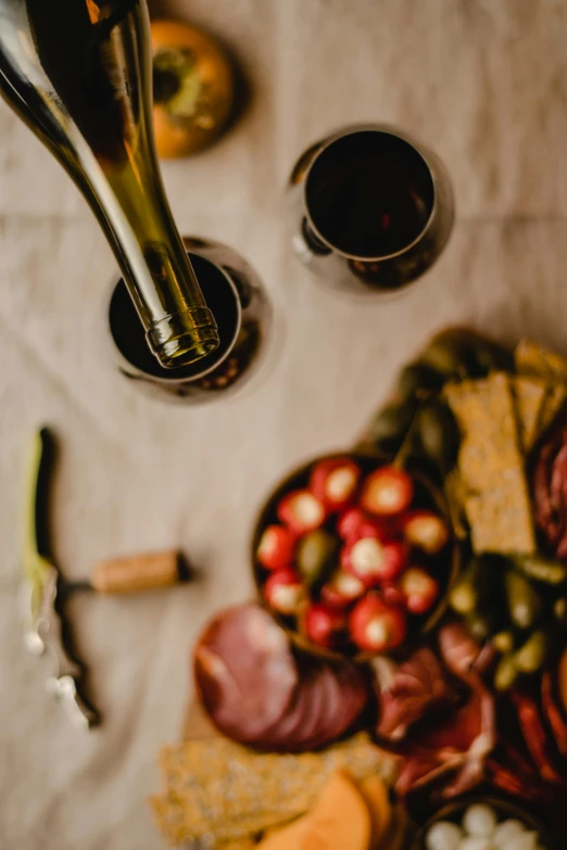 a bottle of wine sitting next to a plate of food, uncropped, food, up-close