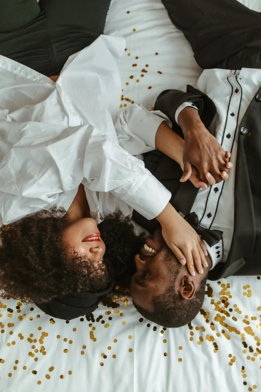 a man and woman laying on a bed covered in confetti, pexels contest winner, renaissance, a black man with long curly hair, white and black clothing, gif, marriage