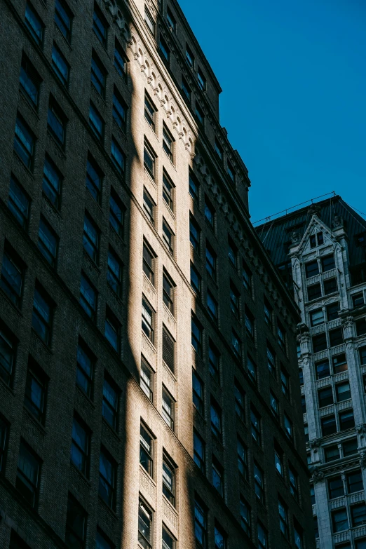 a tall building sitting in the middle of a city, a photo, unsplash contest winner, modernism, glowing light and shadow, new york buildings, neoclassical architecture, flat - color