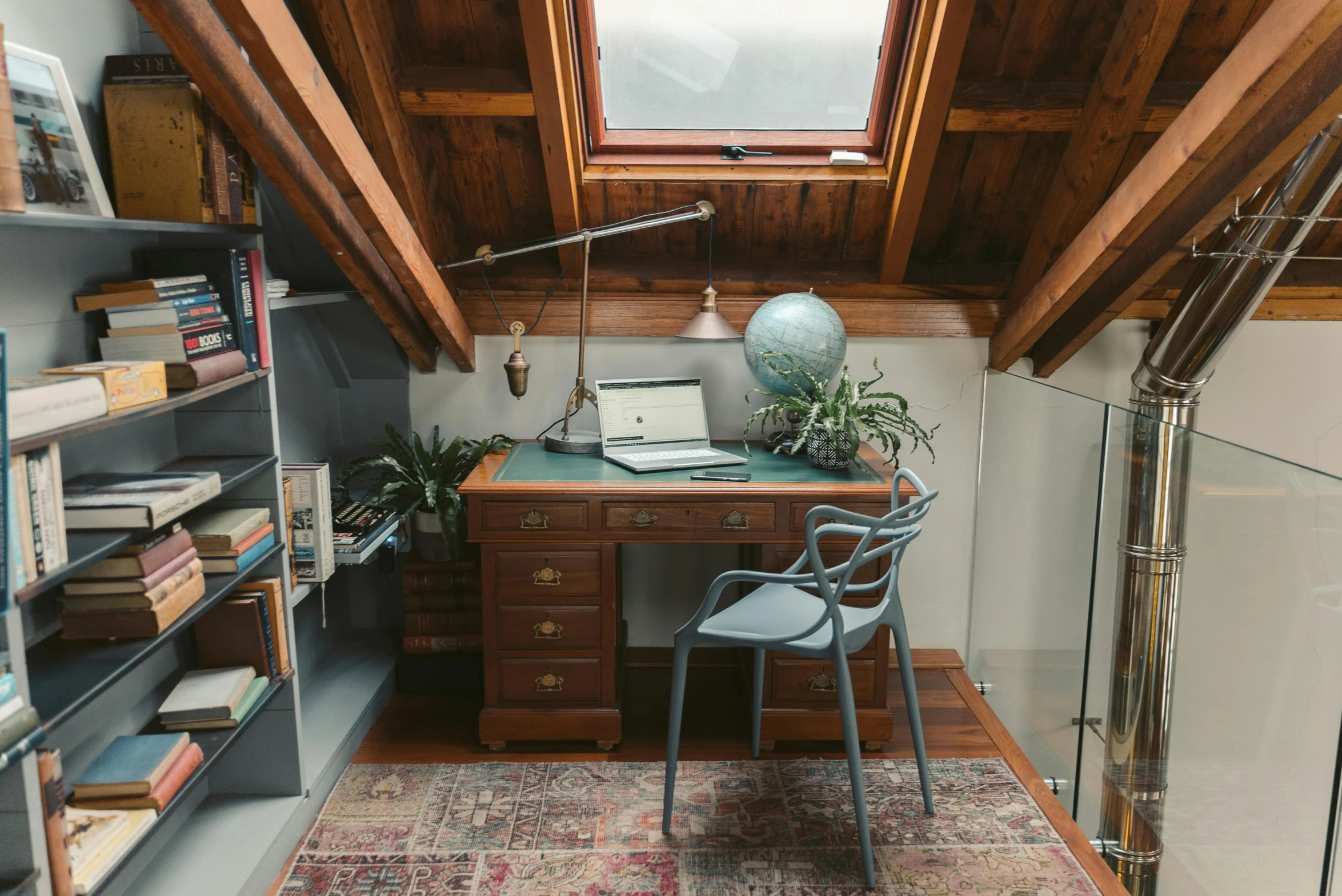 a laptop computer sitting on top of a wooden desk, inspired by John Haberle, light and space, slanted ceiling, vintage - w 1 0 2 4, small library, style of wes anderson