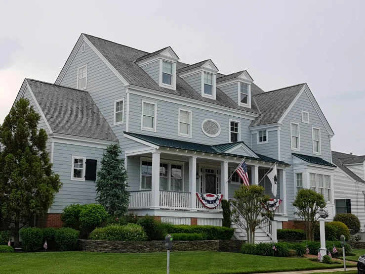 a house with a car parked in front of it, fourth of july, waterfront houses, overcast day, colonial style