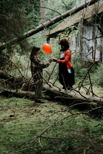 a couple of people standing next to a fallen tree, pexels contest winner, land art, holding a balloon, pennywise style, lesbians, ( ( theatrical ) )