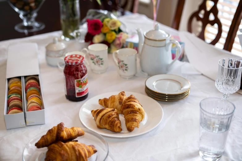 a table that has some croissants on it, profile image, fan favorite, tea party, family photo