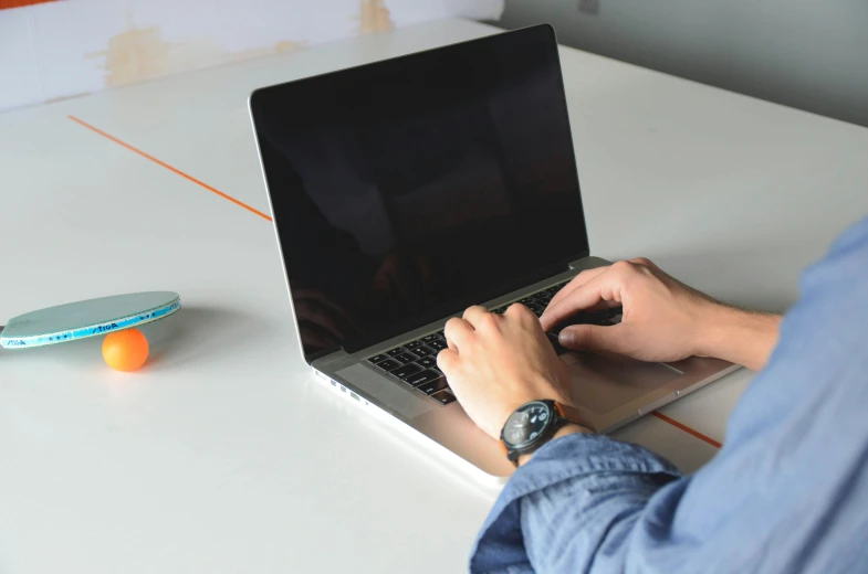 a man sitting at a table using a laptop computer, by Carey Morris, pexels, bottom angle, 9 9 designs, maintenance photo, rectangle