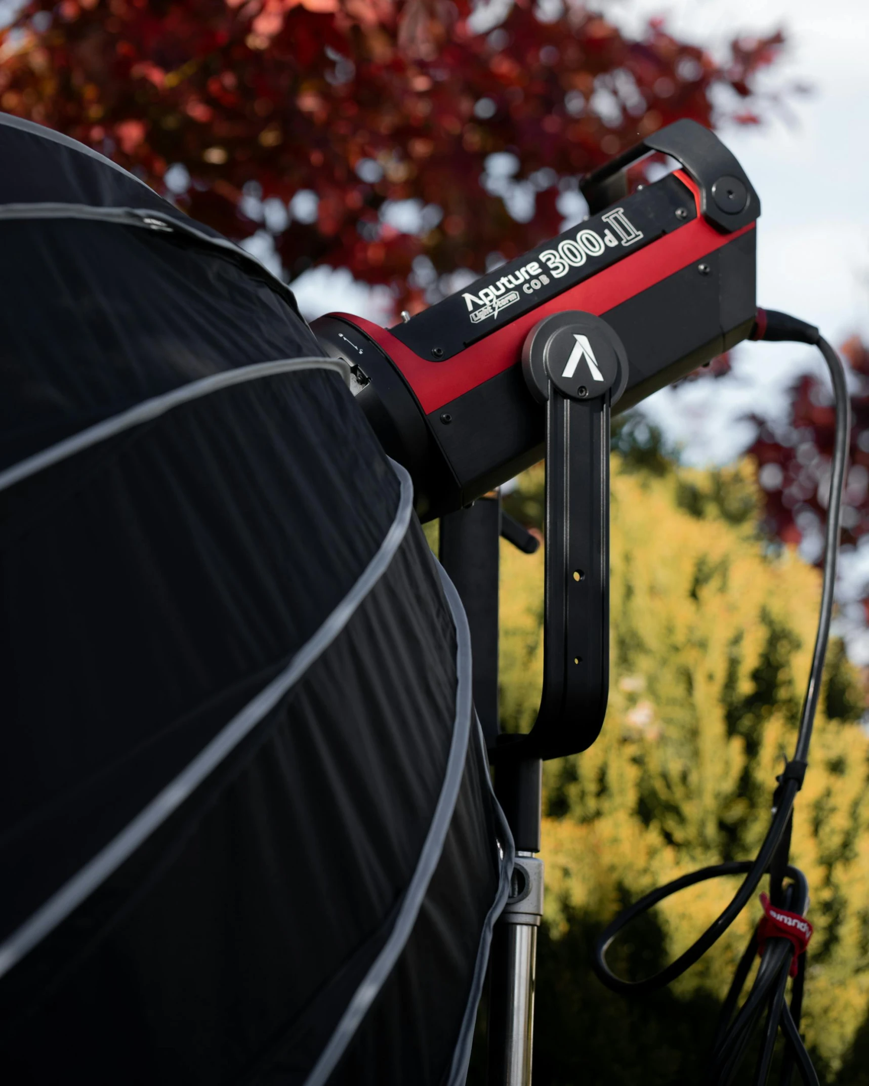 a close up of a camera on a tripod, by Dave Allsop, black and red scheme, covered solar system, lit from the side, striking a pose