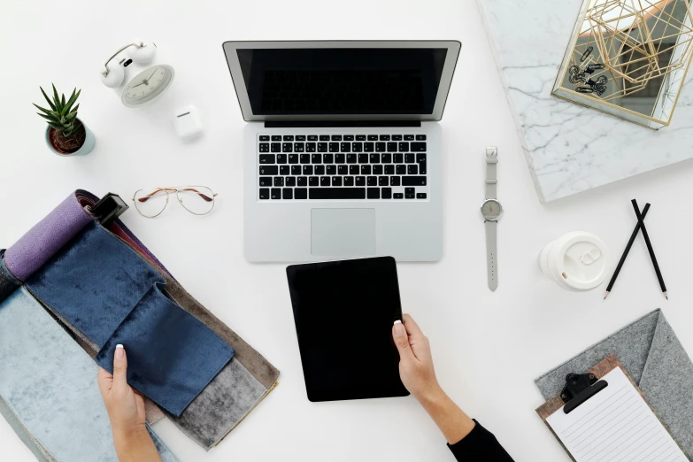 a person sitting at a desk working on a laptop, by Carey Morris, minimalism, 9 9 designs, flat lay, holding notebook, with a white background