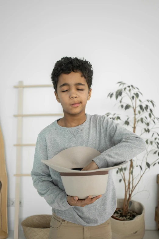 a young boy holding a bowl in his hands, pexels contest winner, process art, unique pot made for houseplants, sleek visor, inspect in inventory image, brown:-2