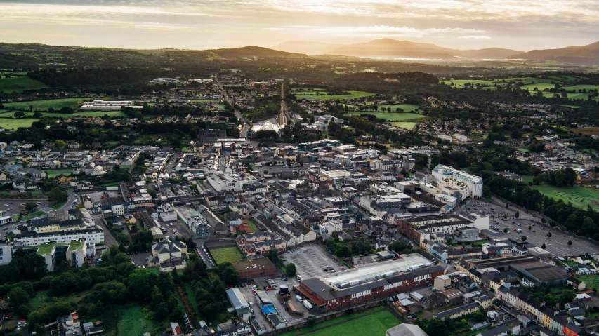 an aerial view of a town with mountains in the background, by Nick Fudge, unsplash, paisley, chesterfield, ultra wide, mayo