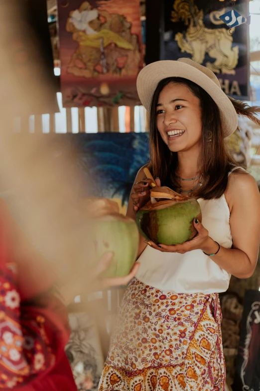 a woman in a hat holding a green coconut, pexels contest winner, happening, offering a plate of food, market setting, a young asian woman, promotional image