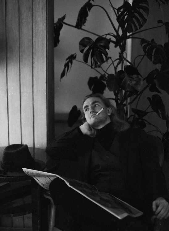 a man sitting in a chair with a cigarette in his mouth, by Maurycy Gottlieb, fine art, in style of cecil beaton, portait image, alvar aalto, carl sagan