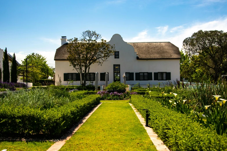 a white house with a garden in front of it, by Hubert van Ravesteyn, pexels contest winner, cape, preserved historical, michelin star restaurant, strathmore 2 0 0