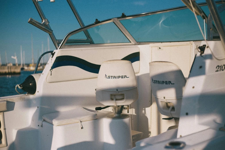 a white boat sitting on top of a body of water, cockpit view, vesper lynd, left eye stripe, y 2 k aesthetic